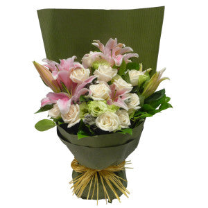 Bouquet de lys roses et de roses blanches emballé dans un cadeau MGM